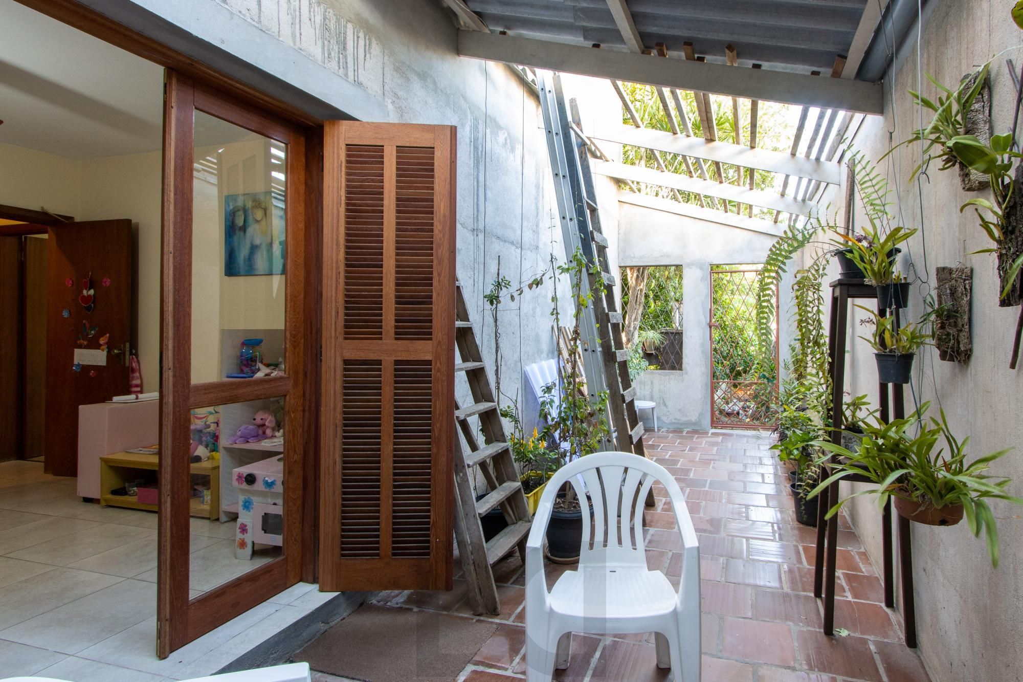 Casa de Alvenaria, possui 3 dormitórios, uma suíte, hall de entrada, lavabo, living com lareira, cozinha ampla com armários, área gourmet com churrasqueira, corredor, pátio e 4 vagas de garagem, uma construção em anexo que possui hall de entrada, lavabo, living, cozinha, escritório, banheiro social — foto 15