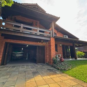 Casa com 220m², 4 dormitórios, 4 suítes, 2 vagas no bairro Igra Norte em Torres para Comprar