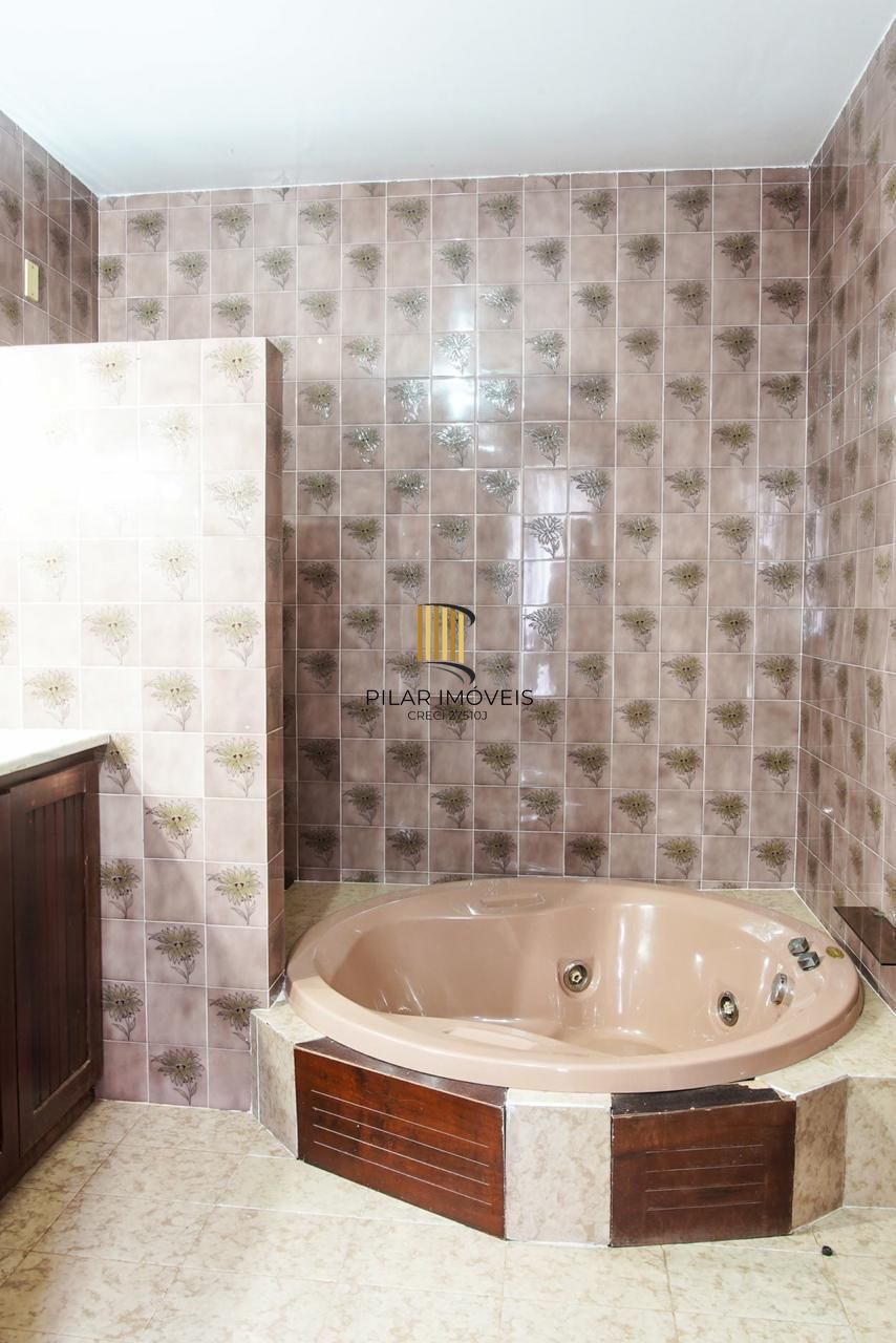 Casa com 300m², localizada na zona sul de Porto Alegre, com lareira, piscina e 3 vagas de garagem cobertas.