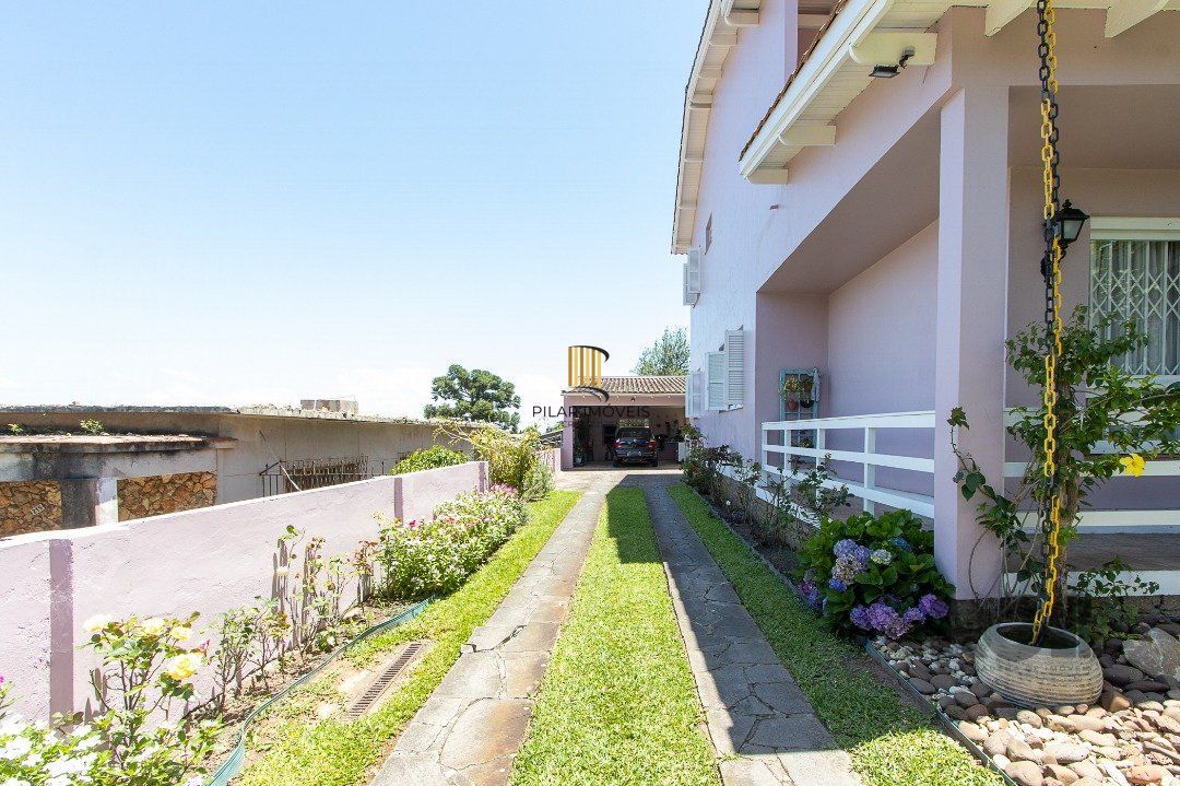 Casa com 4 quartos, suíte, churrasqueira, lareira, garagem coberta e lindo jardim.