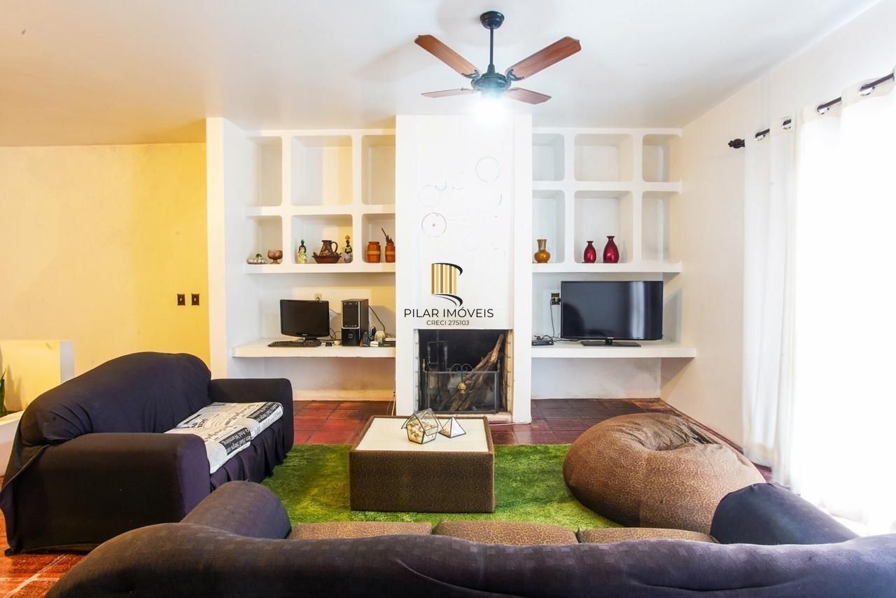 Casa com 300m², localizada na zona sul de Porto Alegre, com lareira, piscina e 3 vagas de garagem cobertas.