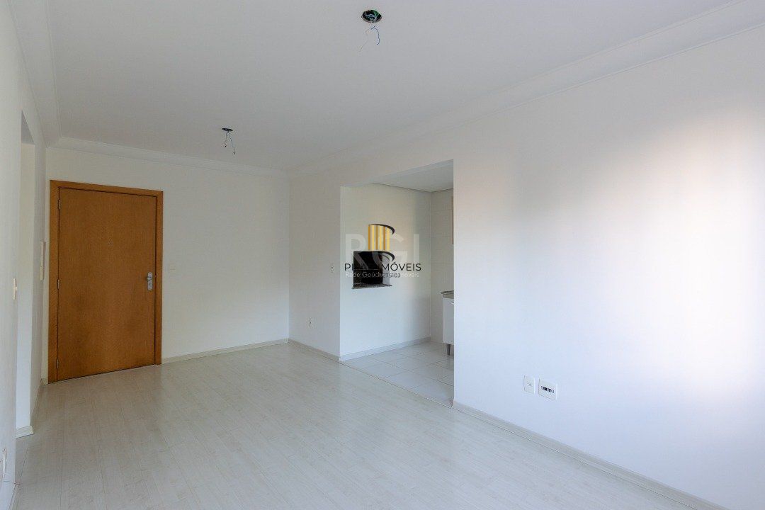 Apartamento de dois dormitórios, uma suíte, living, cozinha com churrasqueira, área de serviço, banheiro social e uma vaga de garagem.