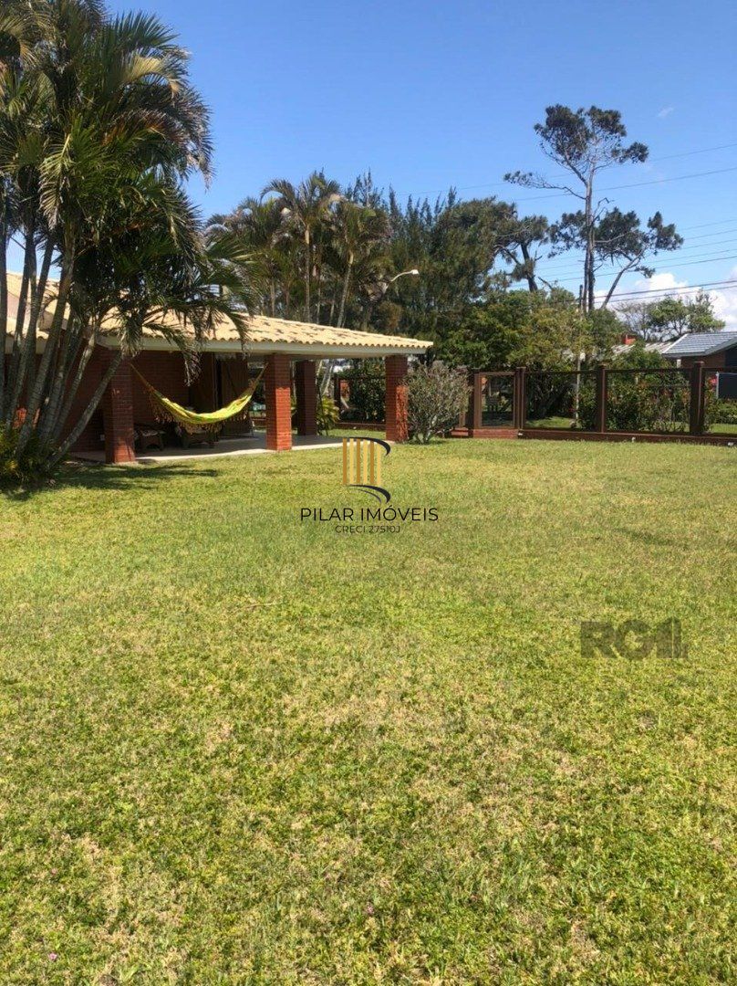 Espaçosa e acolhedora residência numas das esquinas em  charmosa rua de Atlântida, com imenso jardim, paisagismo, lareira,4 dormitórios, sendo  duas suítes.