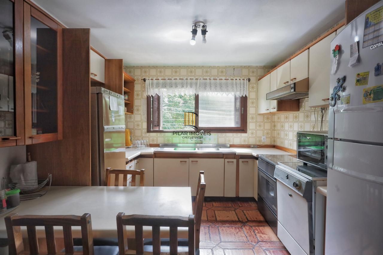 Casa com 300m², localizada na zona sul de Porto Alegre, com lareira, piscina e 3 vagas de garagem cobertas.