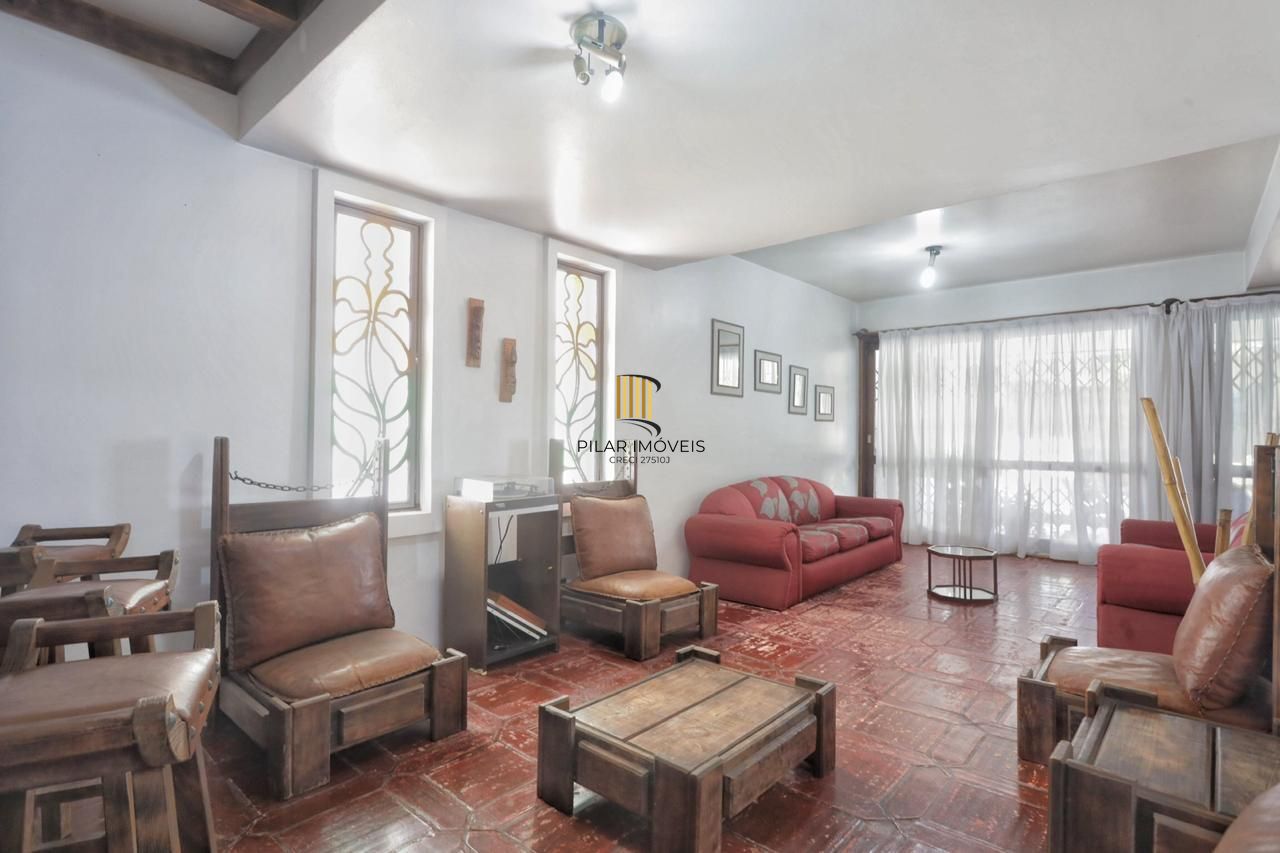 Casa com 300m², localizada na zona sul de Porto Alegre, com lareira, piscina e 3 vagas de garagem cobertas.