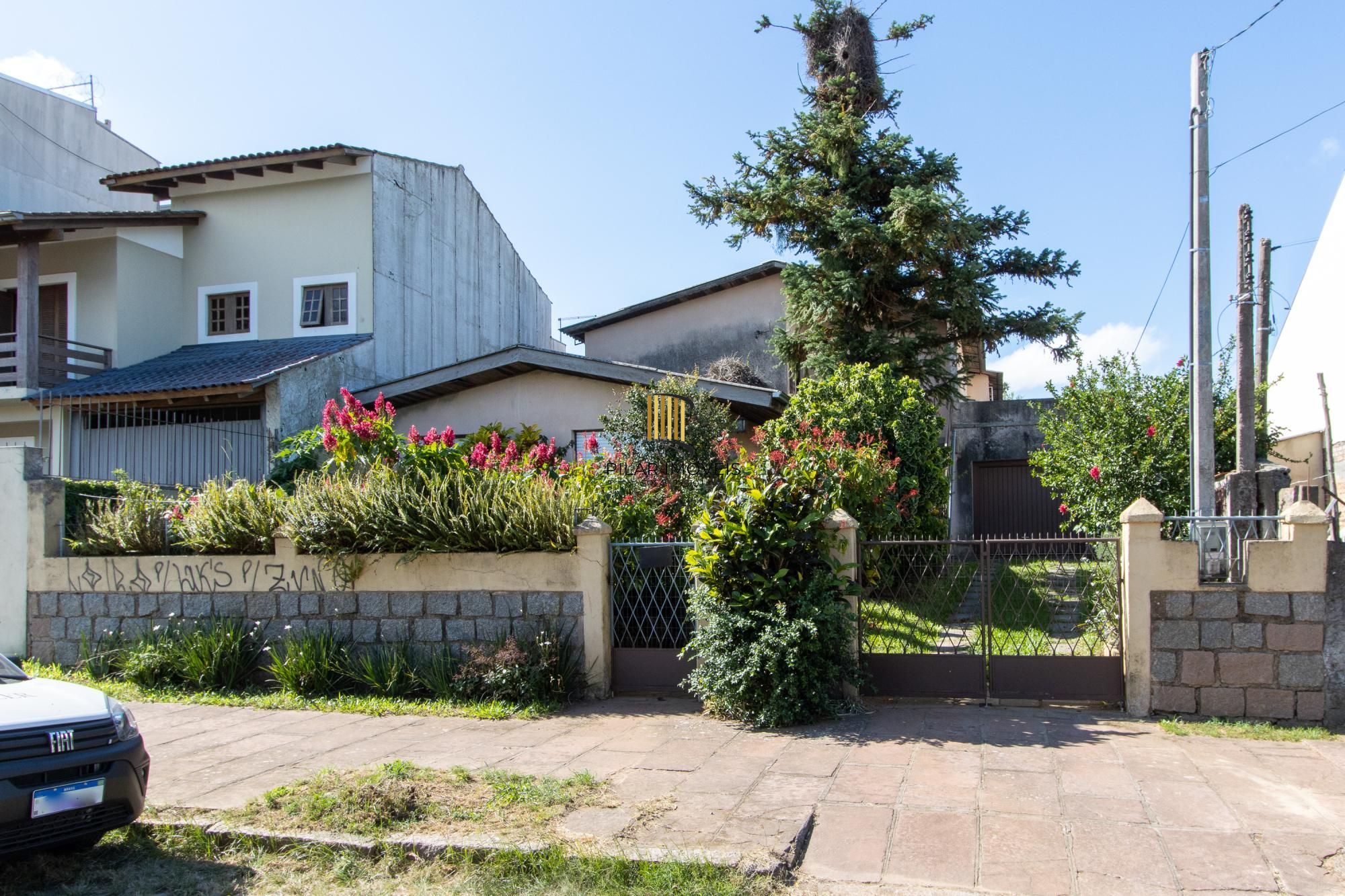 Casa de Alvenaria, possui 3 dormitórios, uma suíte, hall de entrada, lavabo,  living com lareira, cozinha ampla com armários, área gourmet com churrasqueira, corredor, pátio e 4 vagas de garagem, uma construção em anexo que possui hall de entrada, lavabo, living, cozinha, escritório, banheiro social