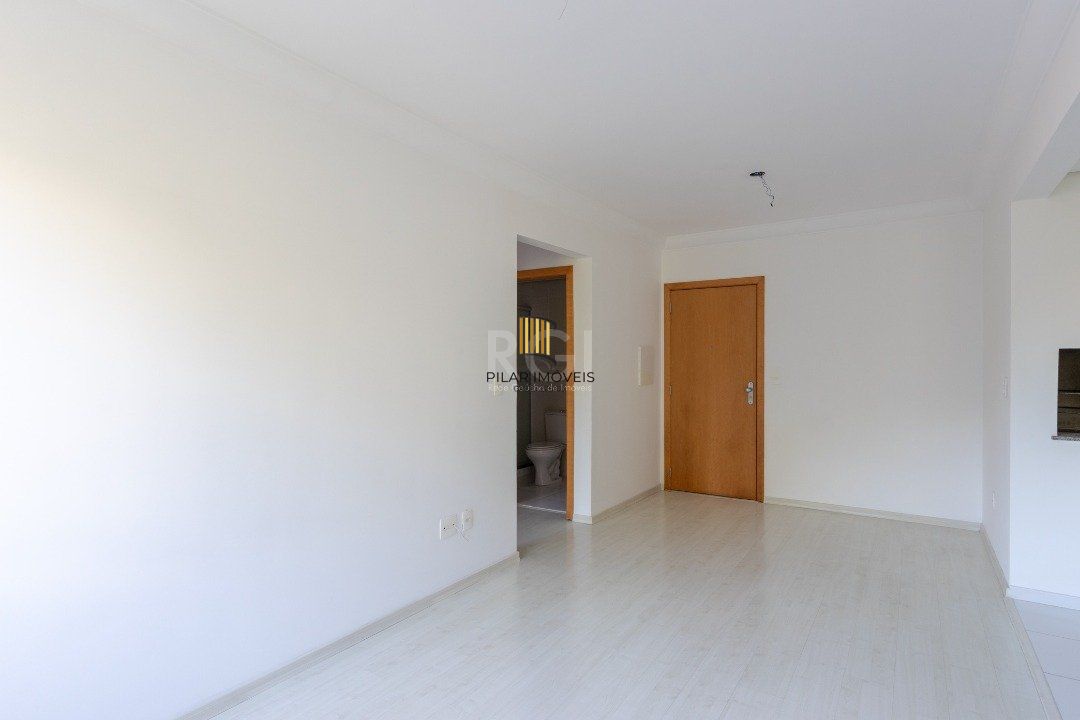Apartamento de dois dormitórios, uma suíte, living, cozinha com churrasqueira, área de serviço, banheiro social e uma vaga de garagem.