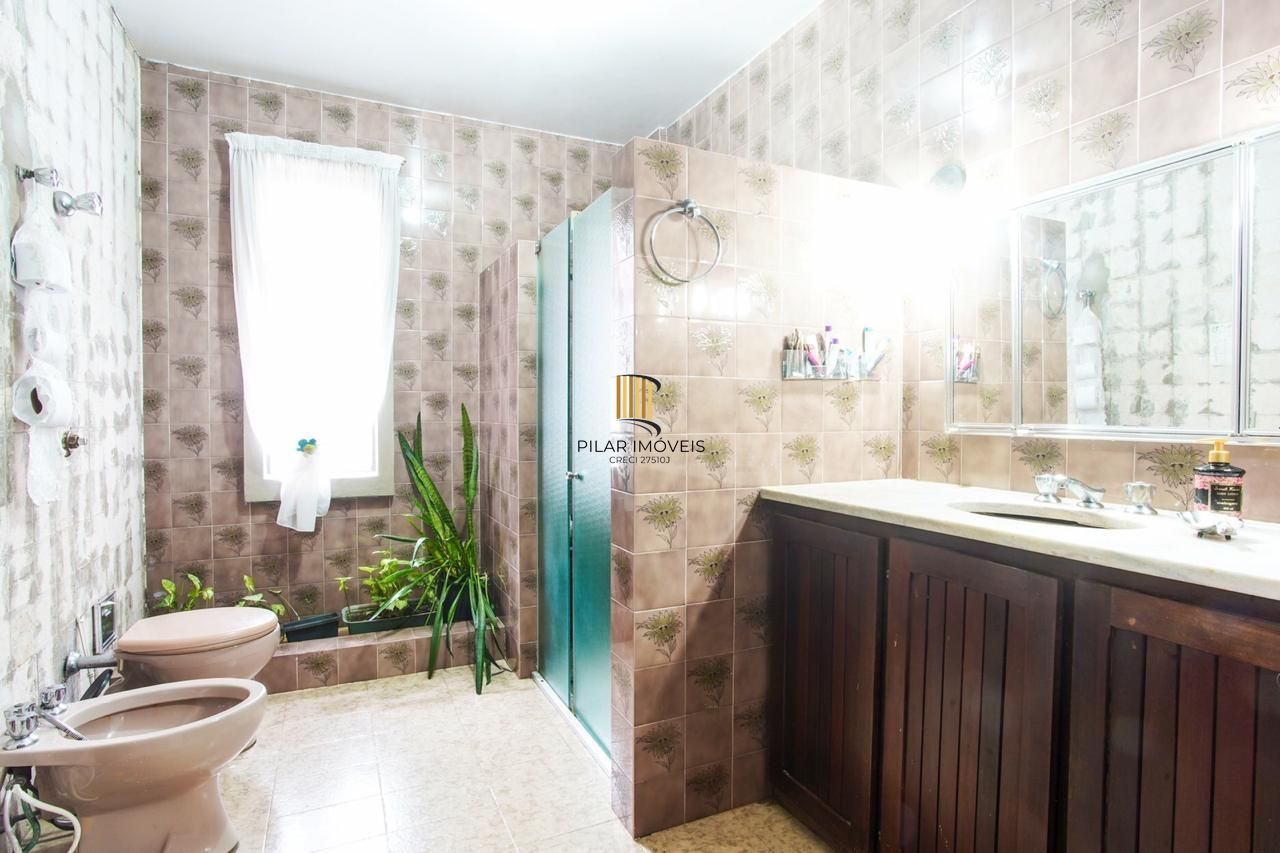 Casa com 300m², localizada na zona sul de Porto Alegre, com lareira, piscina e 3 vagas de garagem cobertas.