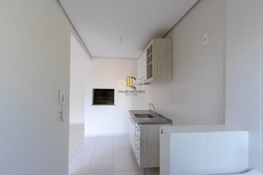 Apartamento de dois dormitórios, uma suíte, living, cozinha com churrasqueira, área de serviço, banheiro social e uma vaga de garagem.