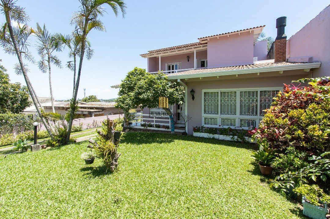 Casa com 4 quartos, suíte, churrasqueira, lareira, garagem coberta e lindo jardim.
