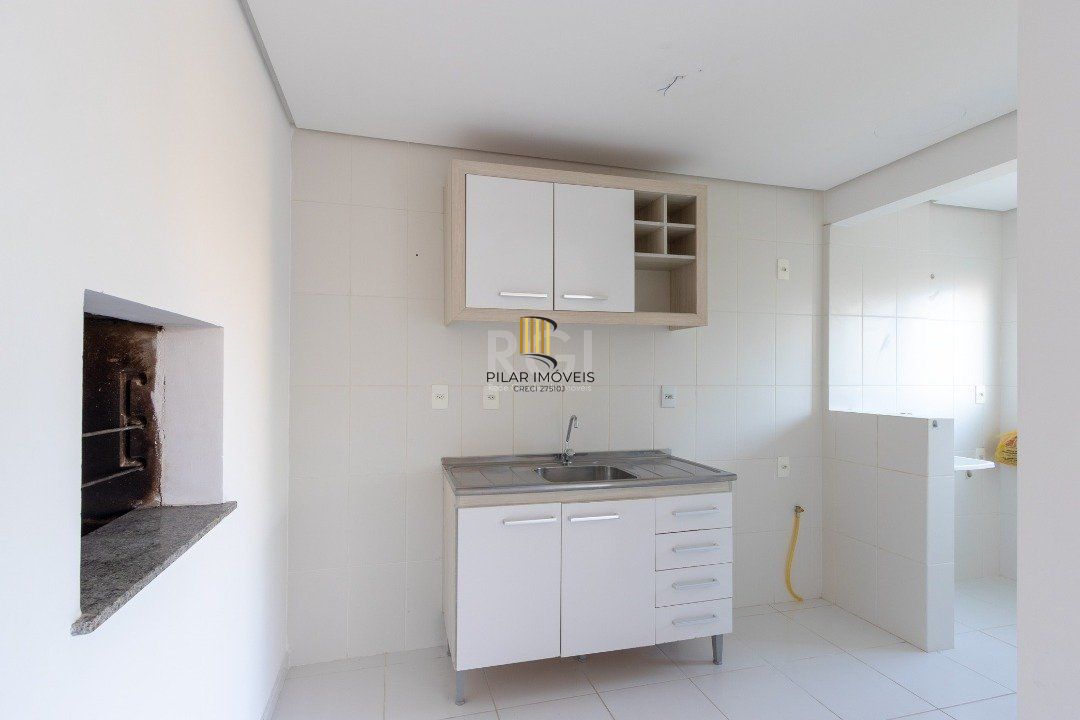 Apartamento de dois dormitórios, uma suíte, living, cozinha com churrasqueira, área de serviço, banheiro social e uma vaga de garagem.