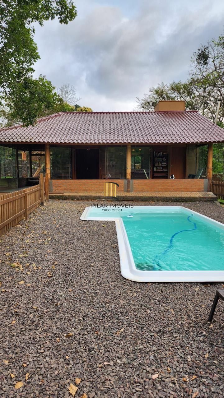 Casa com 2 dormitórios, piscina em terreno totalmente arborizado.