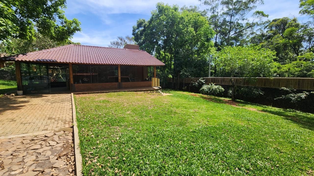 Casa com 2 dormitórios, piscina em terreno totalmente arborizado.
