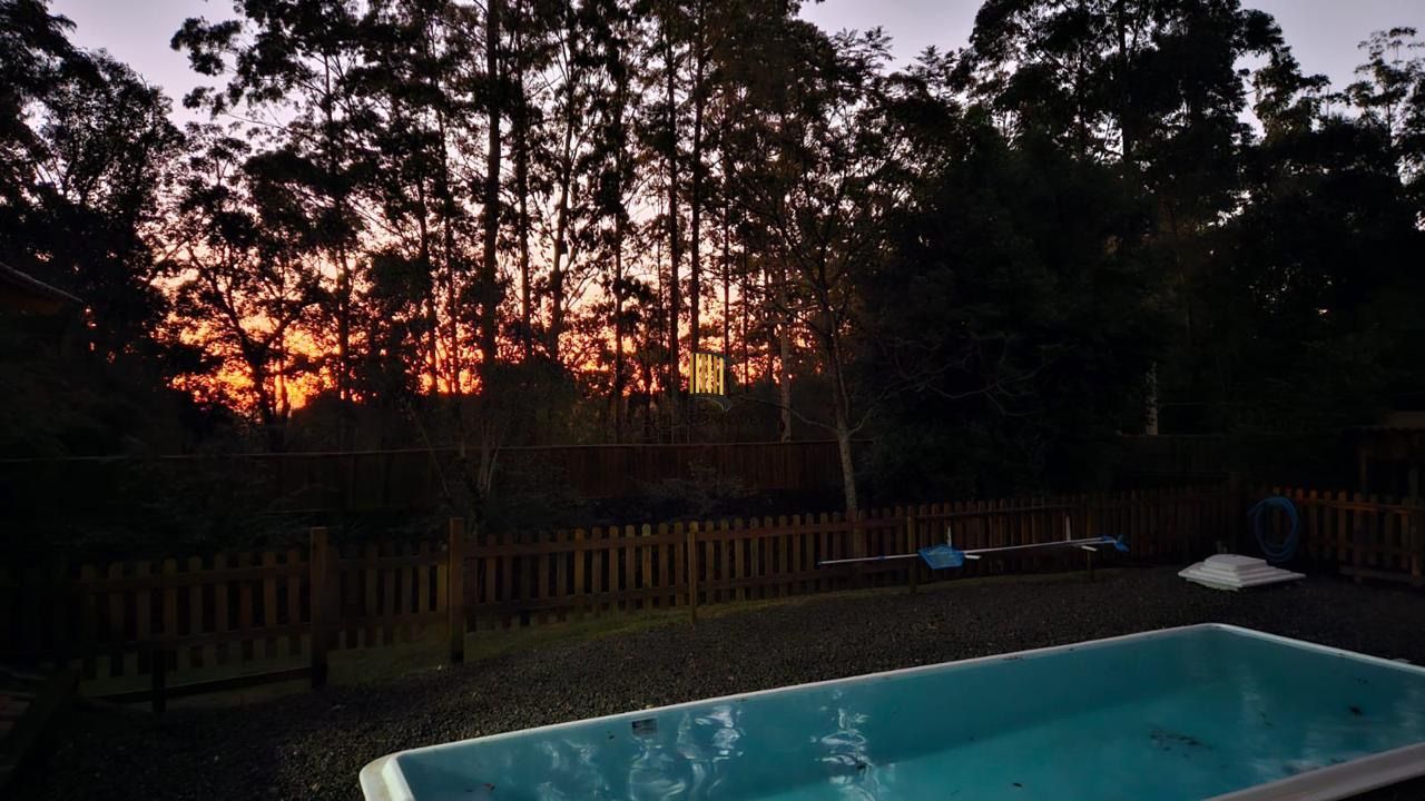 Casa com 2 dormitórios, piscina em terreno totalmente arborizado.