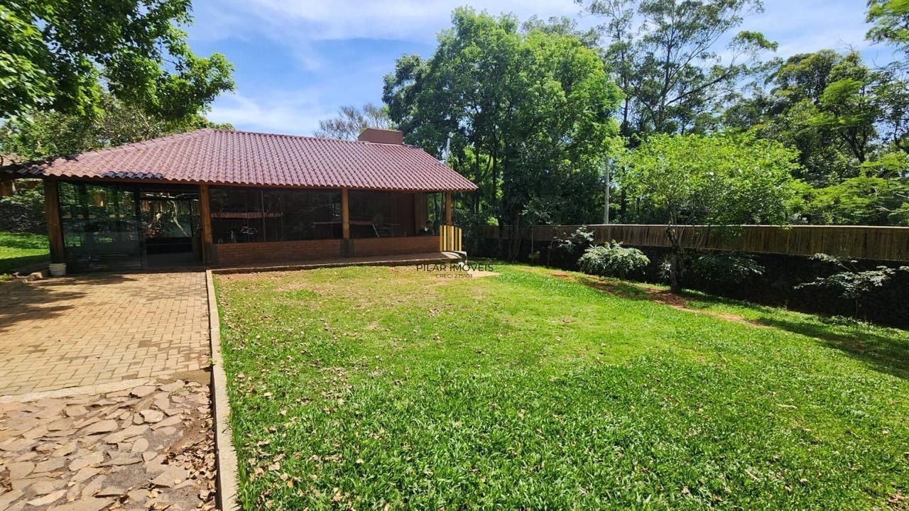 Casa com 2 dormitórios, piscina em terreno totalmente arborizado.