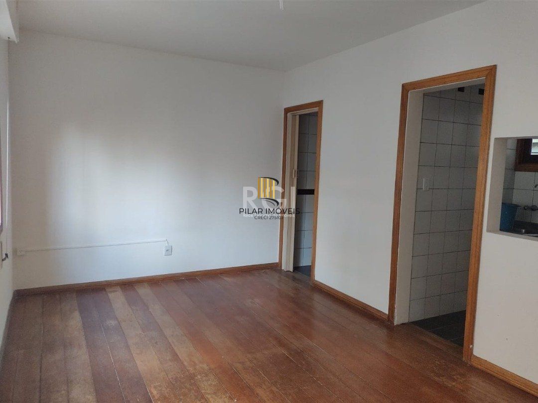 JK no Centro Histórico de Porto Alegre, com 26,01 m², cozinha com pia e armários, banheiro com box, piso com tabuão e orientação solar leste (sol da manhã). 