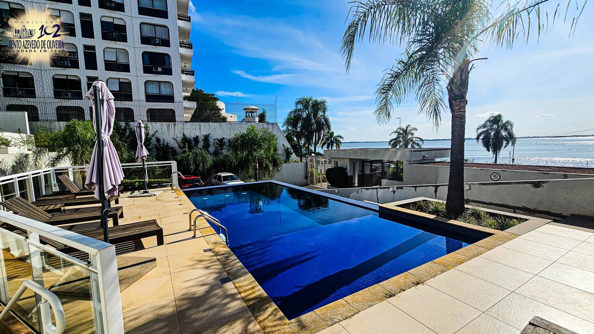 Piscina com espreguiçadeiras e guarda-sóis