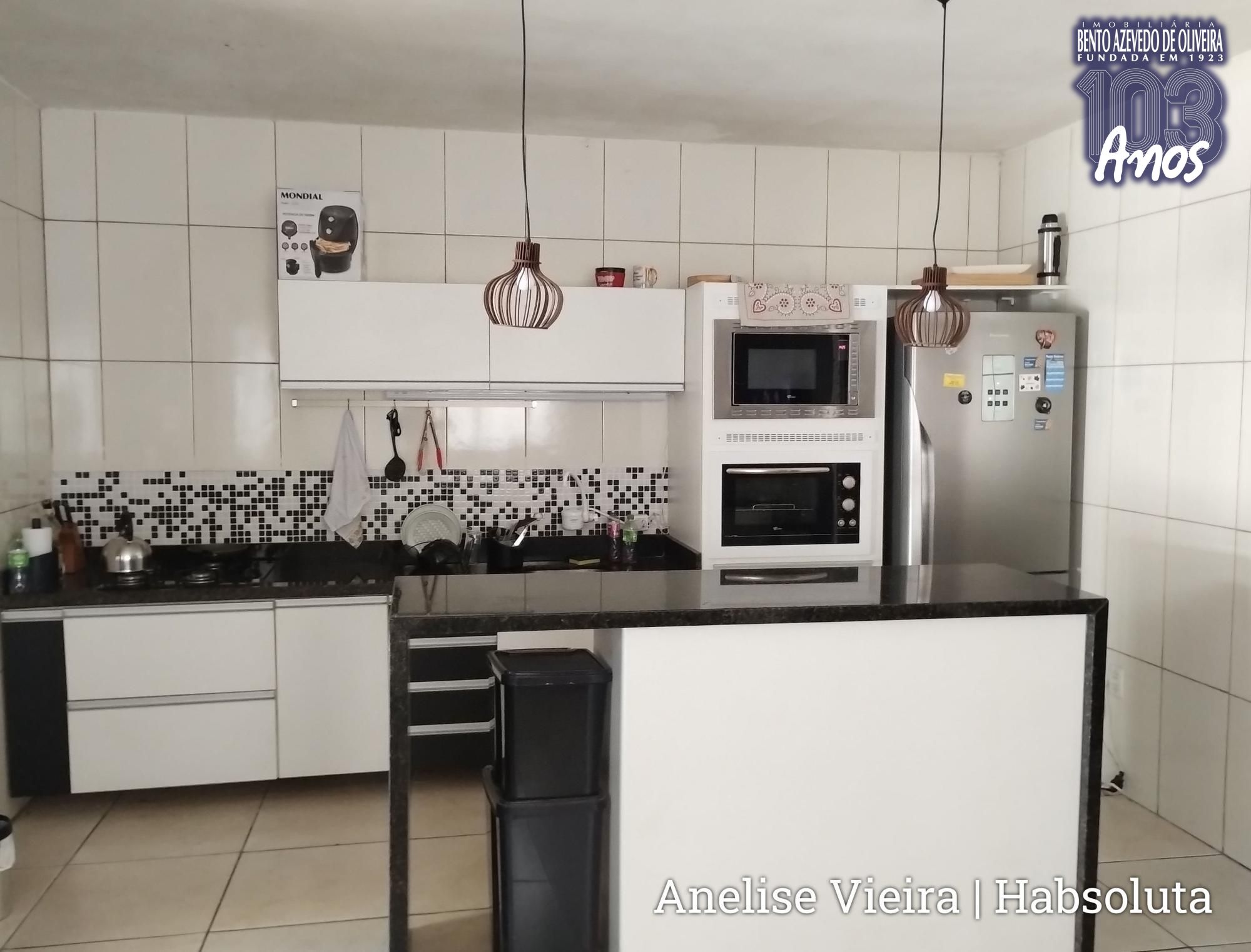 Cozinha ampla com móveis planejados inclusos, integrada à área social dos fundos.