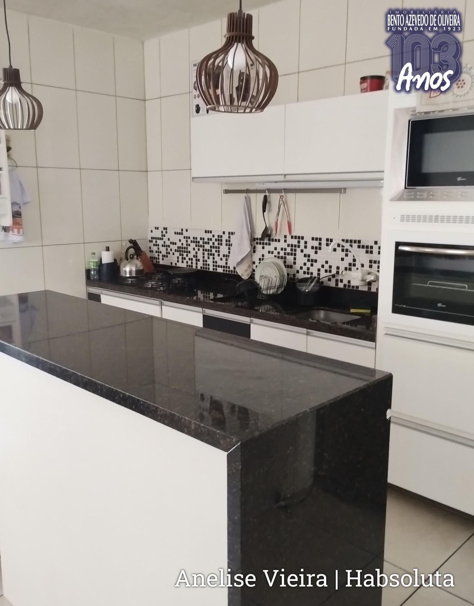 Cozinha ampla com móveis planejados inclusos, integrada à área social dos fundos.