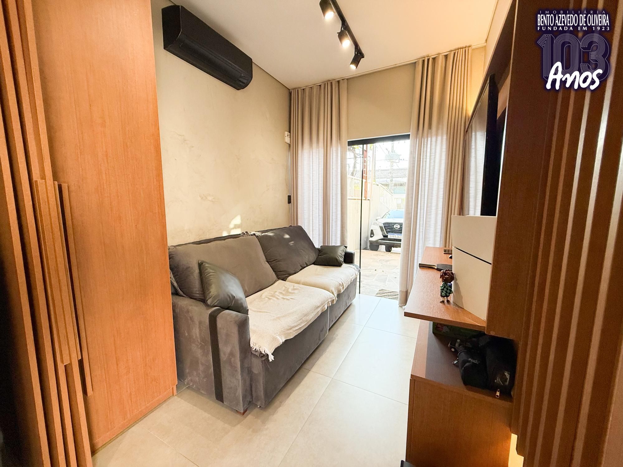 Sala com painel de madeira e televisão