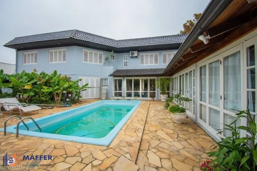 Casa com 3 dormitórios, suíte e amplo pátio com piscina e churrasqueira.