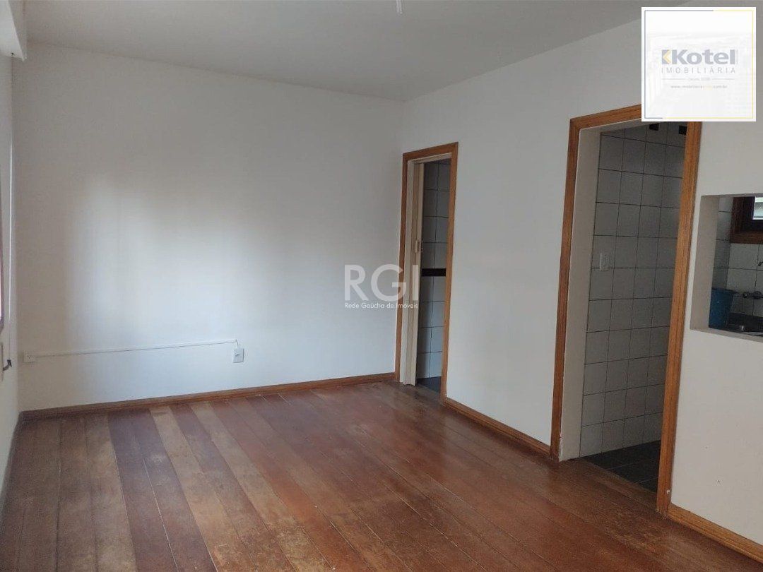 JK no Centro Histórico de Porto Alegre, com 26,01 m², cozinha com pia e armários, banheiro com box, piso com tabuão e orientação solar leste (sol da manhã).