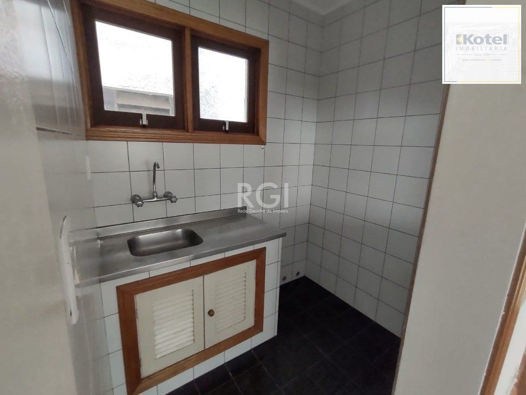 JK no Centro Histórico de Porto Alegre, com 26,01 m², cozinha com pia e armários, banheiro com box, piso com tabuão e orientação solar leste (sol da manhã).