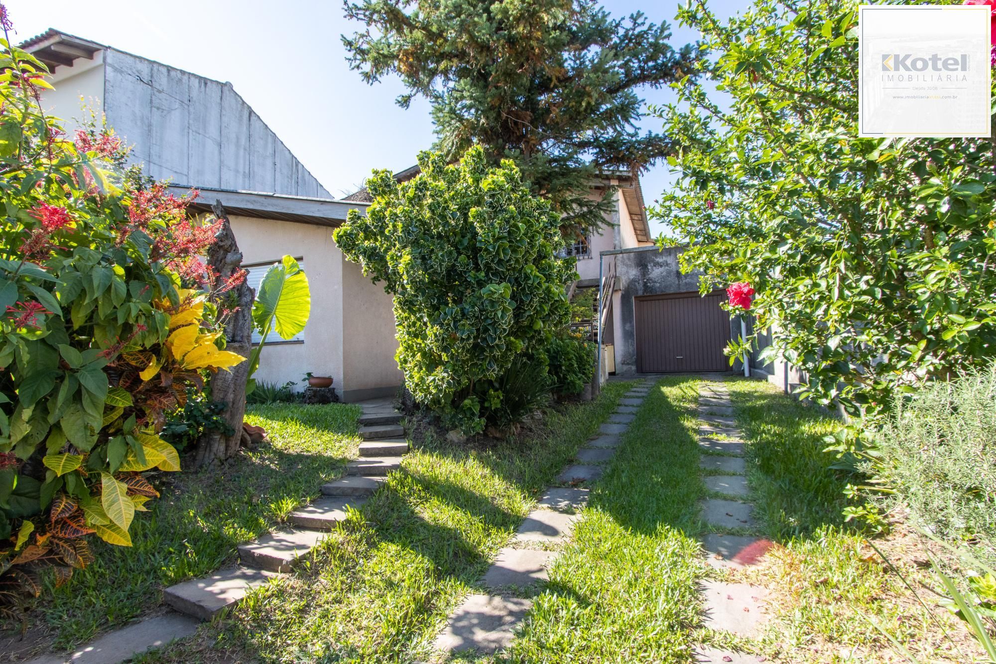 Casa de Alvenaria, possui 3 dormitórios, uma suíte, hall de entrada, lavabo,  living com lareira, cozinha ampla com armários, área gourmet com churrasqueira, corredor, pátio e 4 vagas de garagem, uma construção em anexo que possui hall de entrada, lavabo, living, cozinha, escritório, banheiro social — foto 3