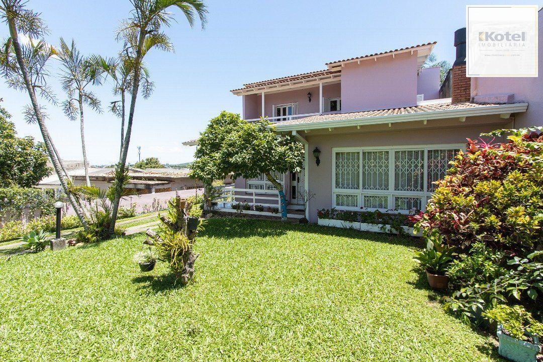 Casa com 4 quartos, suíte, churrasqueira, lareira, garagem coberta e lindo jardim.