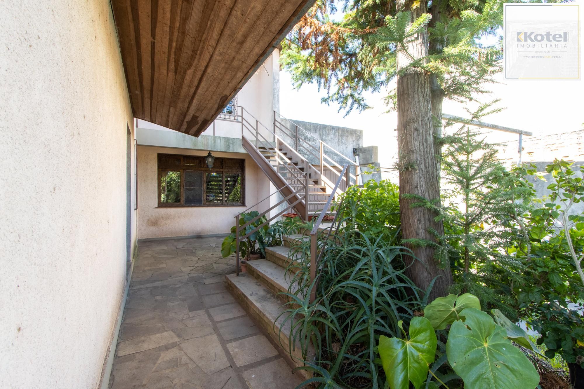 Casa de Alvenaria, possui 3 dormitórios, uma suíte, hall de entrada, lavabo,  living com lareira, cozinha ampla com armários, área gourmet com churrasqueira, corredor, pátio e 4 vagas de garagem, uma construção em anexo que possui hall de entrada, lavabo, living, cozinha, escritório, banheiro social — foto 5