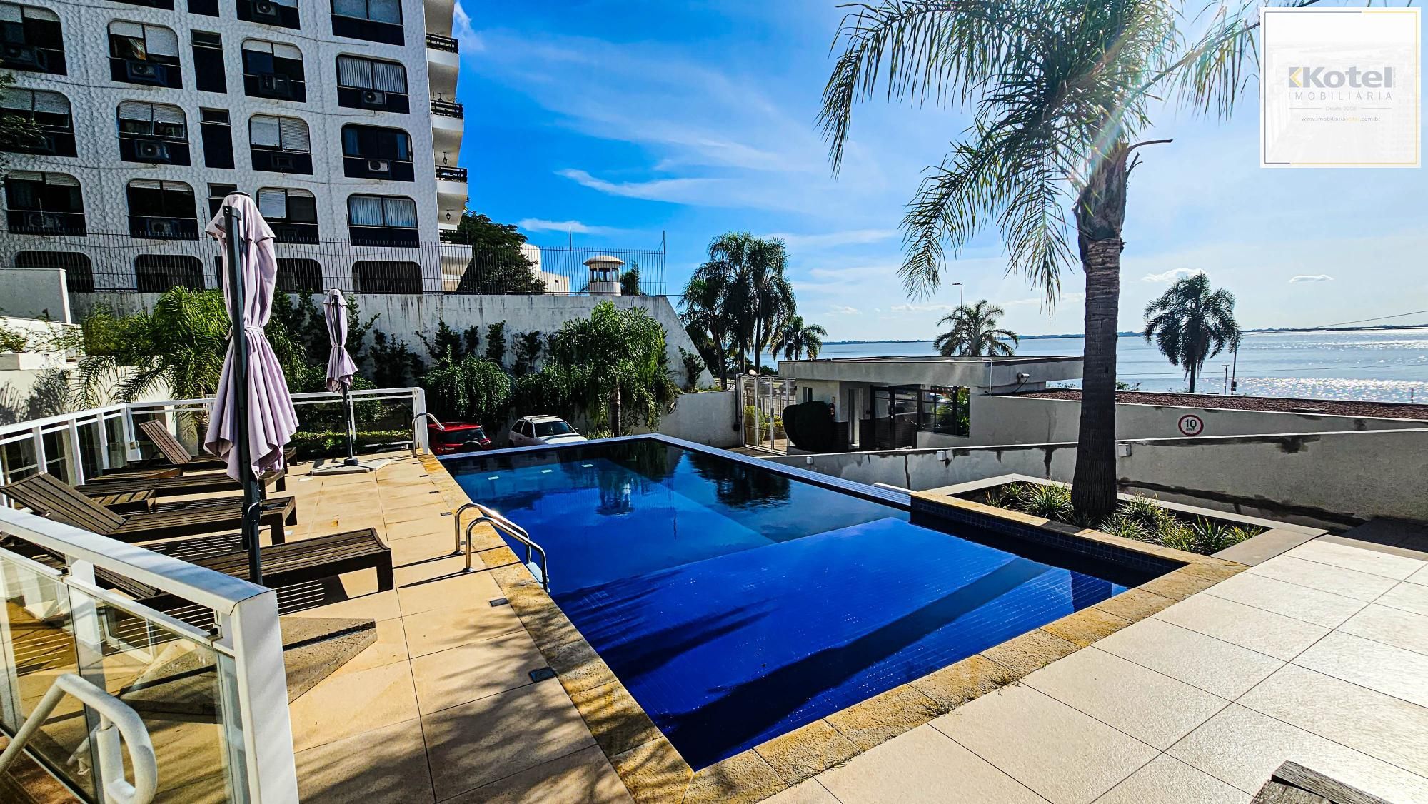 Piscina com espreguiçadeiras e guarda-sóis