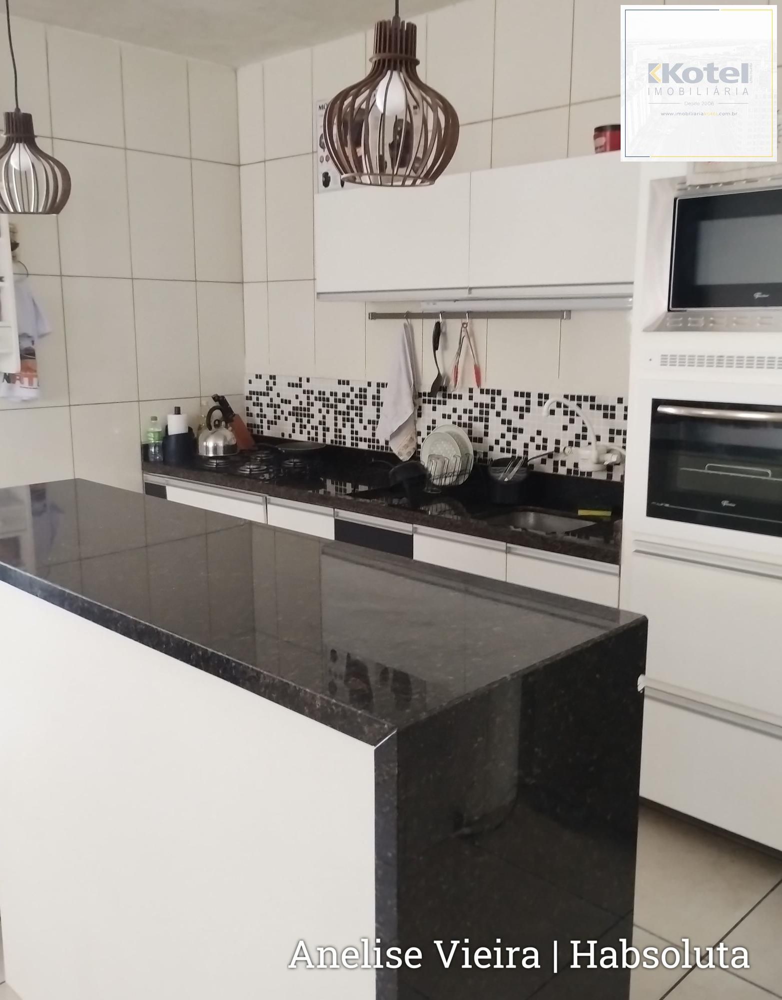 Cozinha ampla com móveis planejados inclusos, integrada à área social dos fundos.