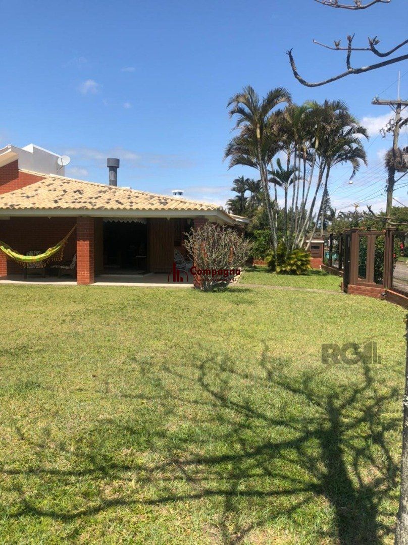 Espaçosa e acolhedora residência numas das esquinas em  charmosa rua de Atlântida, com imenso jardim, paisagismo, lareira,4 dormitórios, sendo  duas suítes. — foto 3