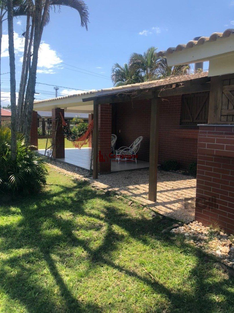 Espaçosa e acolhedora residência numas das esquinas em  charmosa rua de Atlântida, com imenso jardim, paisagismo, lareira,4 dormitórios, sendo  duas suítes. — foto 4