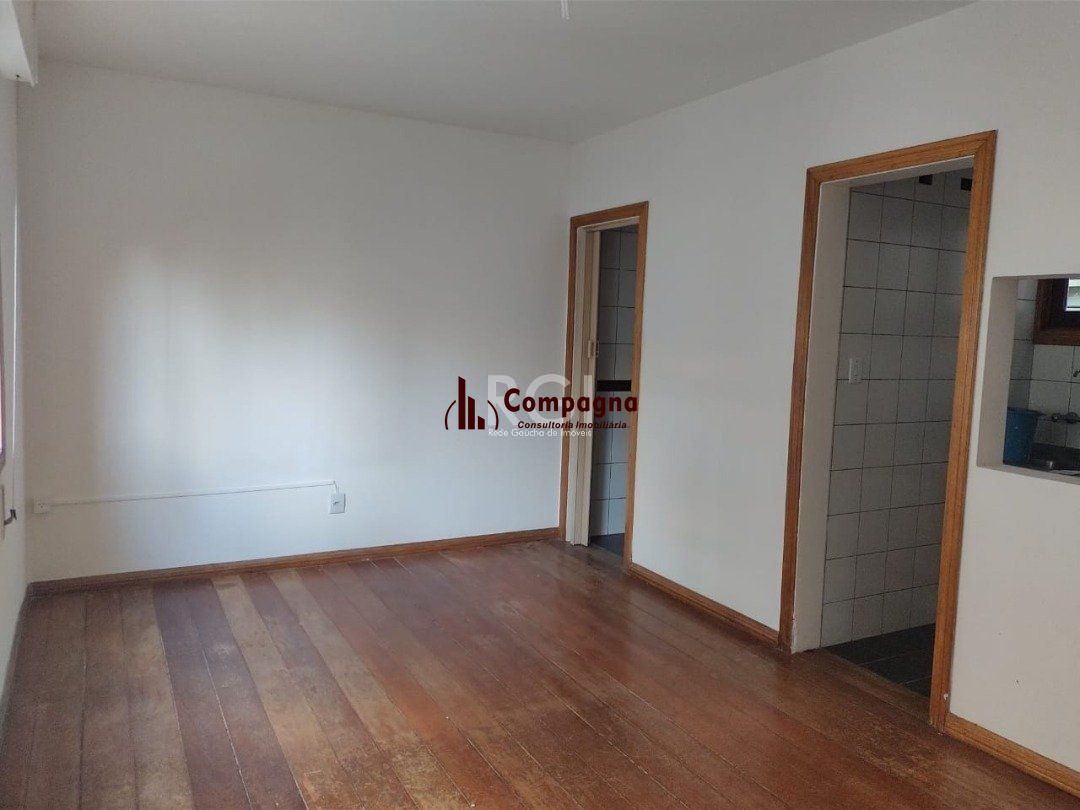 JK no Centro Histórico de Porto Alegre, com 26,01 m², cozinha com pia e armários, banheiro com box, piso com tabuão e orientação solar leste (sol da manhã). — foto 2