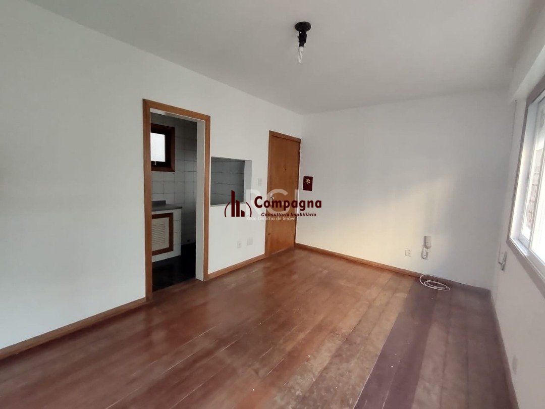 JK no Centro Histórico de Porto Alegre, com 26,01 m², cozinha com pia e armários, banheiro com box, piso com tabuão e orientação solar leste (sol da manhã). — foto 3