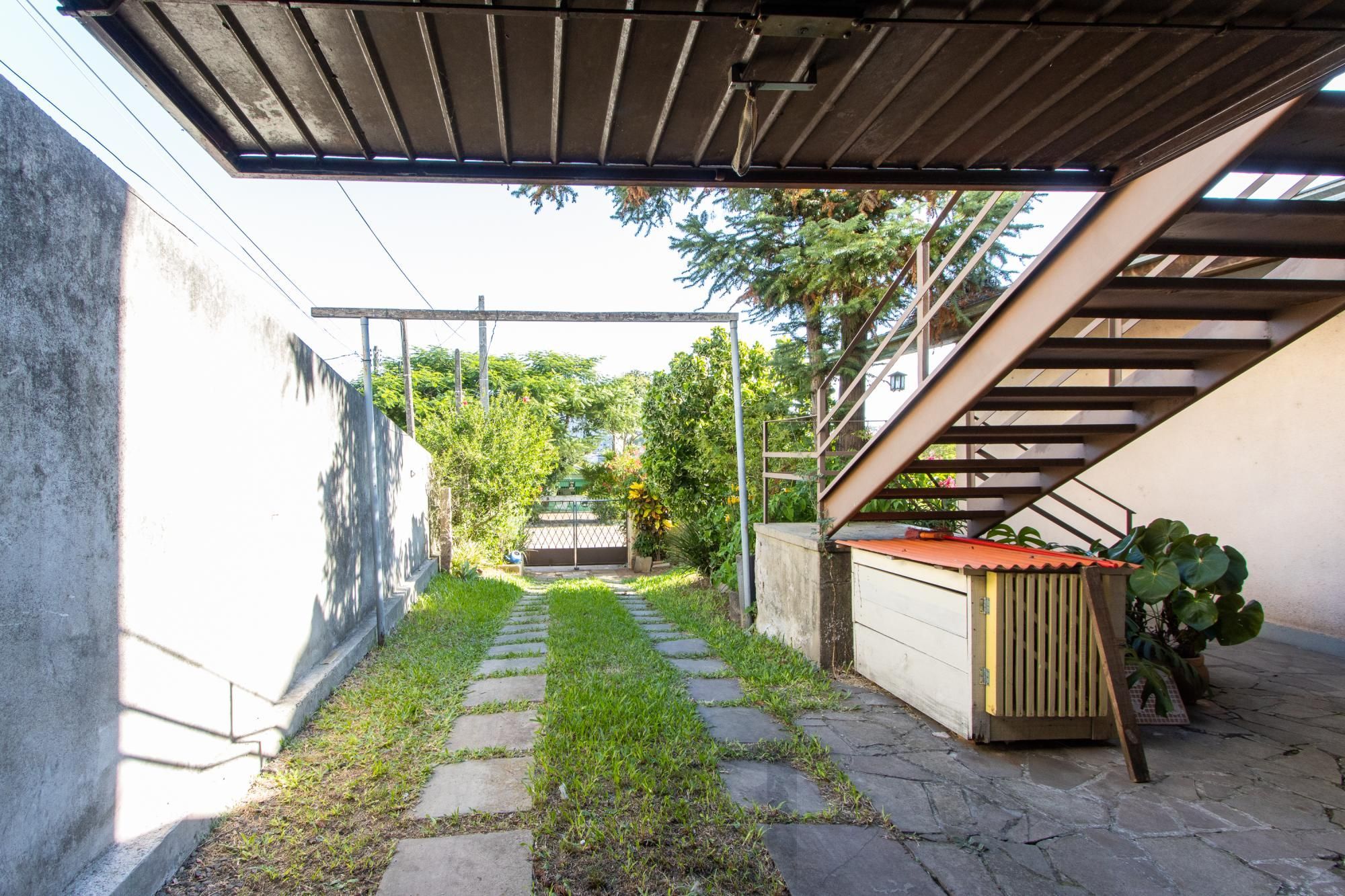 Casa de Alvenaria, possui 3 dormitórios, uma suíte, hall de entrada, lavabo, living com lareira, cozinha ampla com armários, área gourmet com churrasqueira, corredor, pátio e 4 vagas de garagem, uma construção em anexo que possui hall de entrada, lavabo, living, cozinha, escritório, banheiro social — foto 54