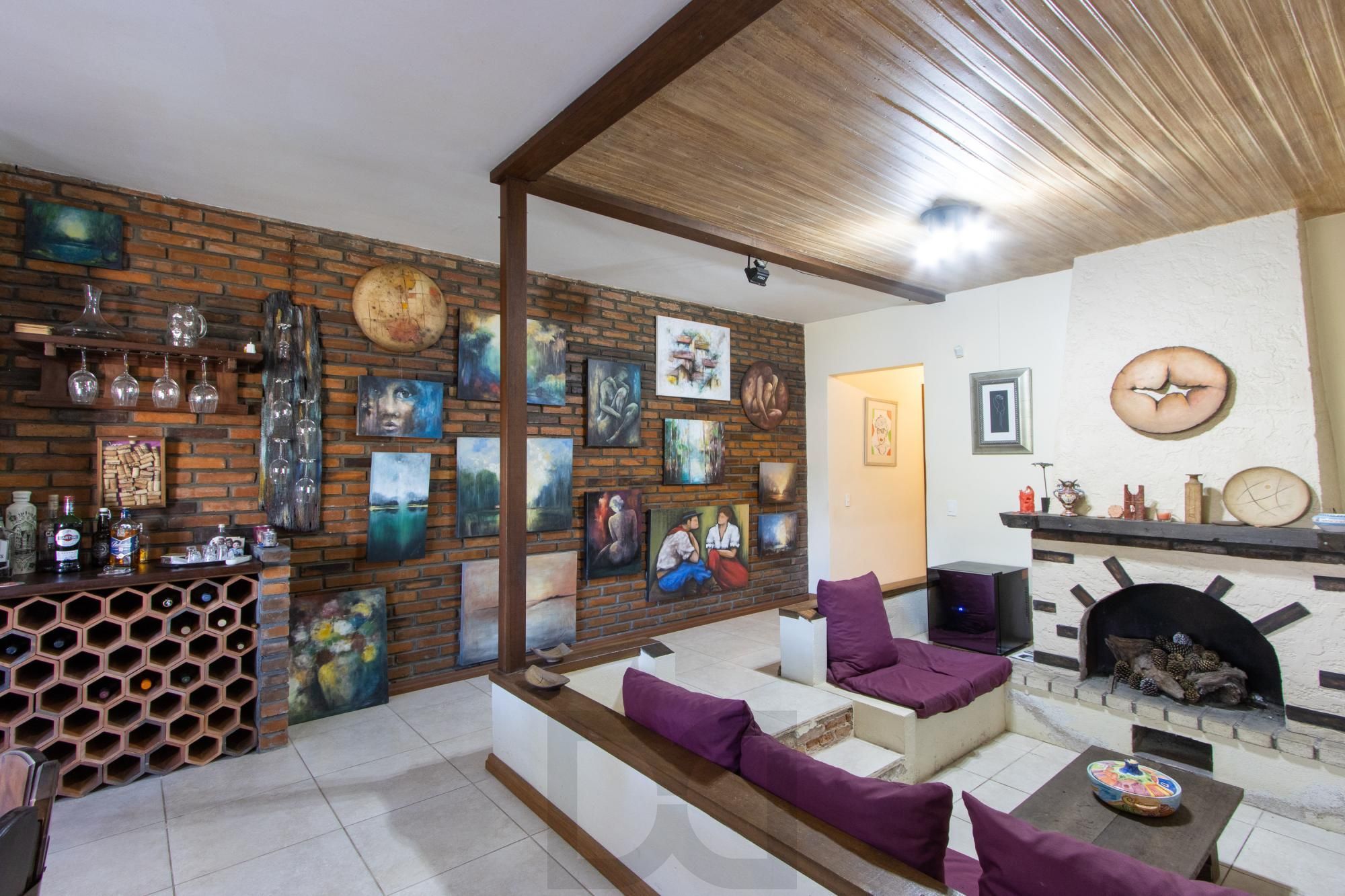 Casa de Alvenaria, possui 3 dormitórios, uma suíte, hall de entrada, lavabo, living com lareira, cozinha ampla com armários, área gourmet com churrasqueira, corredor, pátio e 4 vagas de garagem, uma construção em anexo que possui hall de entrada, lavabo, living, cozinha, escritório, banheiro social — foto 8