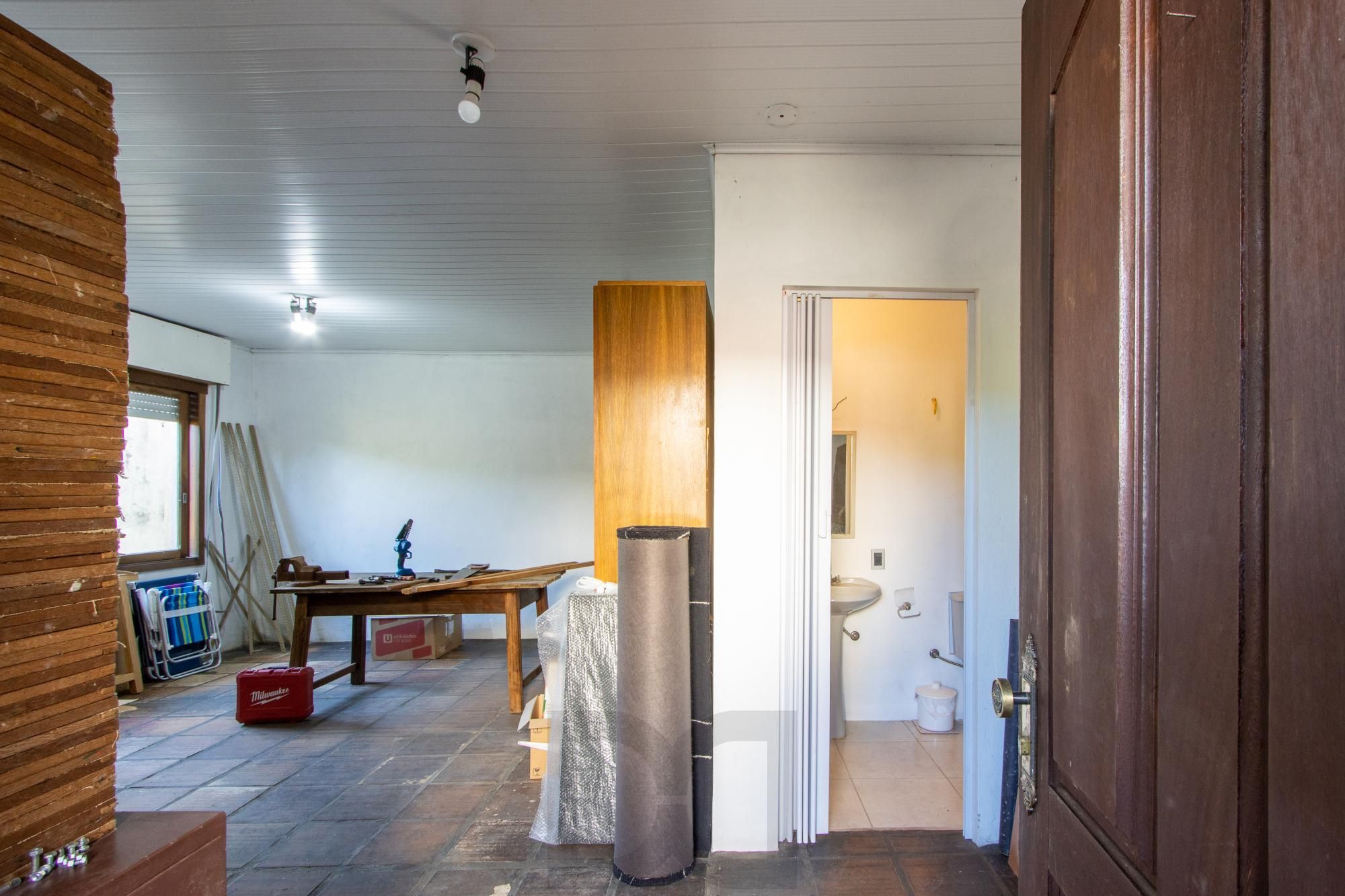 Casa de Alvenaria, possui 3 dormitórios, uma suíte, hall de entrada, lavabo, living com lareira, cozinha ampla com armários, área gourmet com churrasqueira, corredor, pátio e 4 vagas de garagem, uma construção em anexo que possui hall de entrada, lavabo, living, cozinha, escritório, banheiro social — foto 55