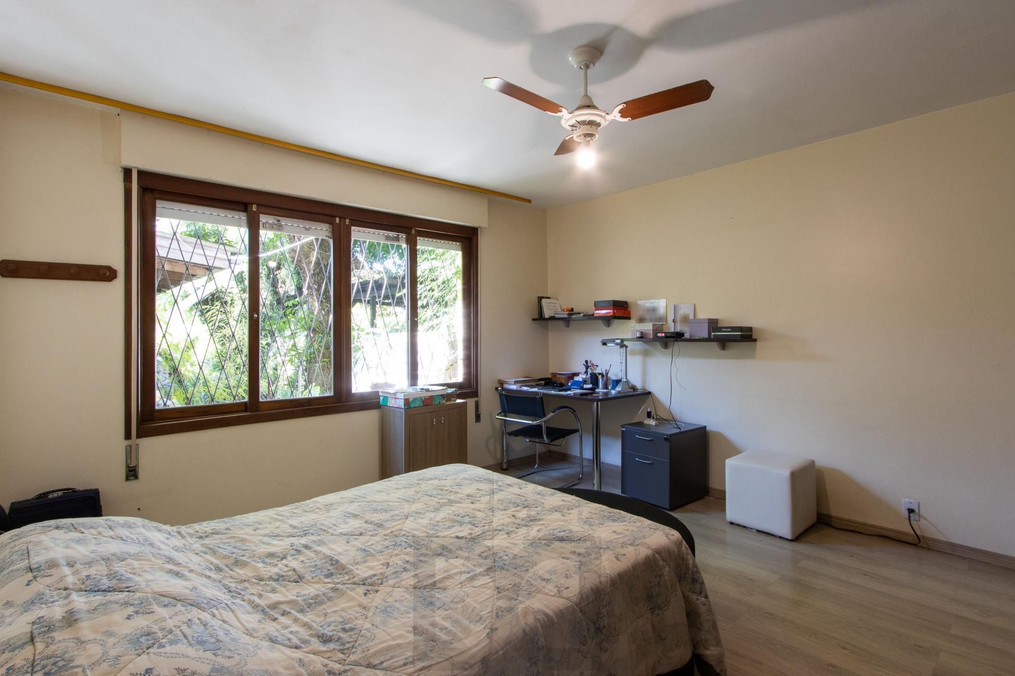 Casa de Alvenaria, possui 3 dormitórios, uma suíte, hall de entrada, lavabo, living com lareira, cozinha ampla com armários, área gourmet com churrasqueira, corredor, pátio e 4 vagas de garagem, uma construção em anexo que possui hall de entrada, lavabo, living, cozinha, escritório, banheiro social — foto 23