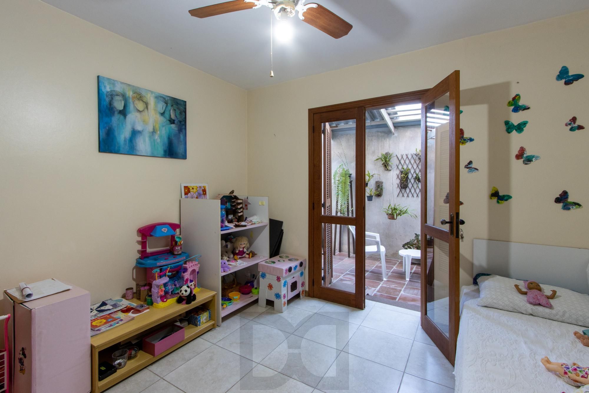 Casa de Alvenaria, possui 3 dormitórios, uma suíte, hall de entrada, lavabo, living com lareira, cozinha ampla com armários, área gourmet com churrasqueira, corredor, pátio e 4 vagas de garagem, uma construção em anexo que possui hall de entrada, lavabo, living, cozinha, escritório, banheiro social — foto 13
