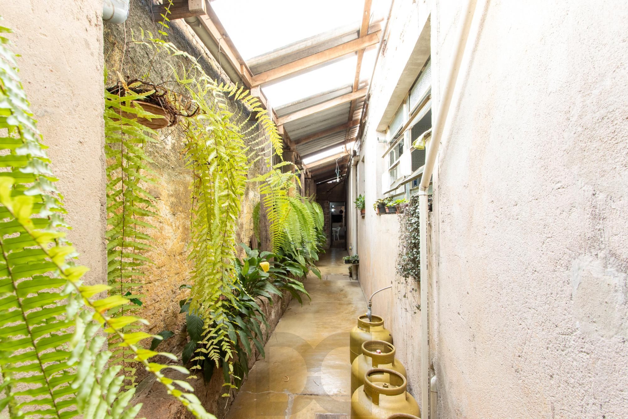 Casa de Alvenaria, possui 3 dormitórios, uma suíte, hall de entrada, lavabo, living com lareira, cozinha ampla com armários, área gourmet com churrasqueira, corredor, pátio e 4 vagas de garagem, uma construção em anexo que possui hall de entrada, lavabo, living, cozinha, escritório, banheiro social — foto 27