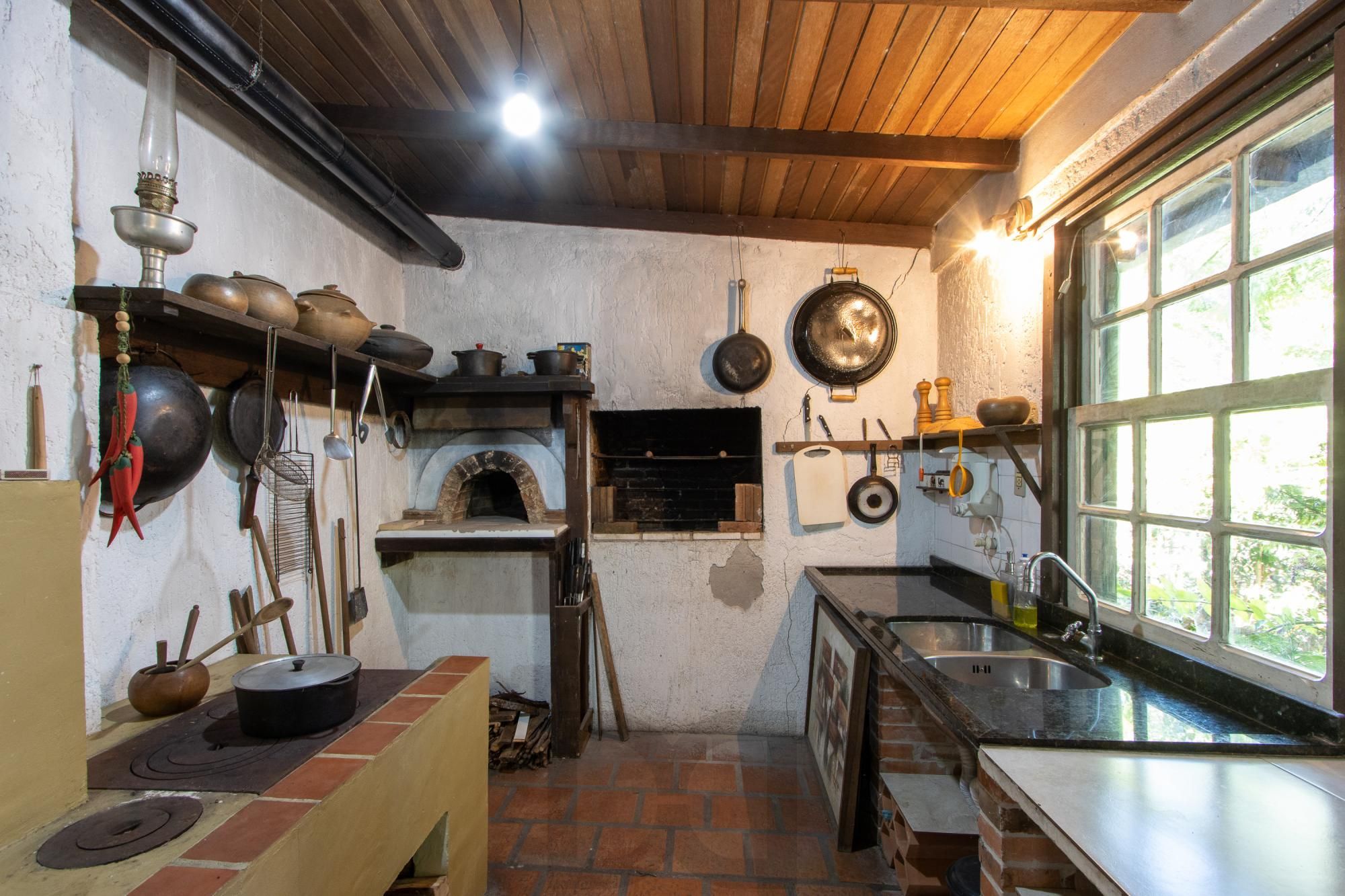 Casa de Alvenaria, possui 3 dormitórios, uma suíte, hall de entrada, lavabo, living com lareira, cozinha ampla com armários, área gourmet com churrasqueira, corredor, pátio e 4 vagas de garagem, uma construção em anexo que possui hall de entrada, lavabo, living, cozinha, escritório, banheiro social — foto 29