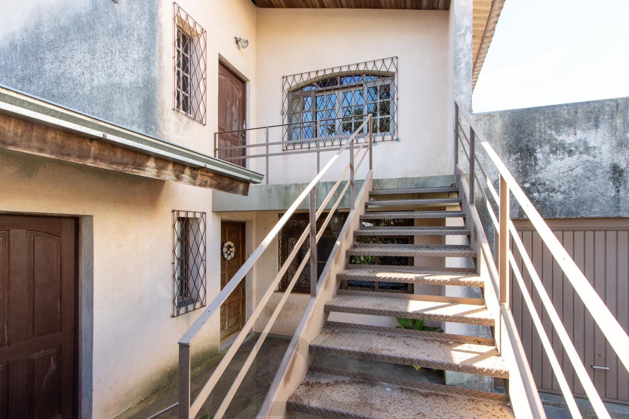 Casa de Alvenaria, possui 3 dormitórios, uma suíte, hall de entrada, lavabo, living com lareira, cozinha ampla com armários, área gourmet com churrasqueira, corredor, pátio e 4 vagas de garagem, uma construção em anexo que possui hall de entrada, lavabo, living, cozinha, escritório, banheiro social — foto 35