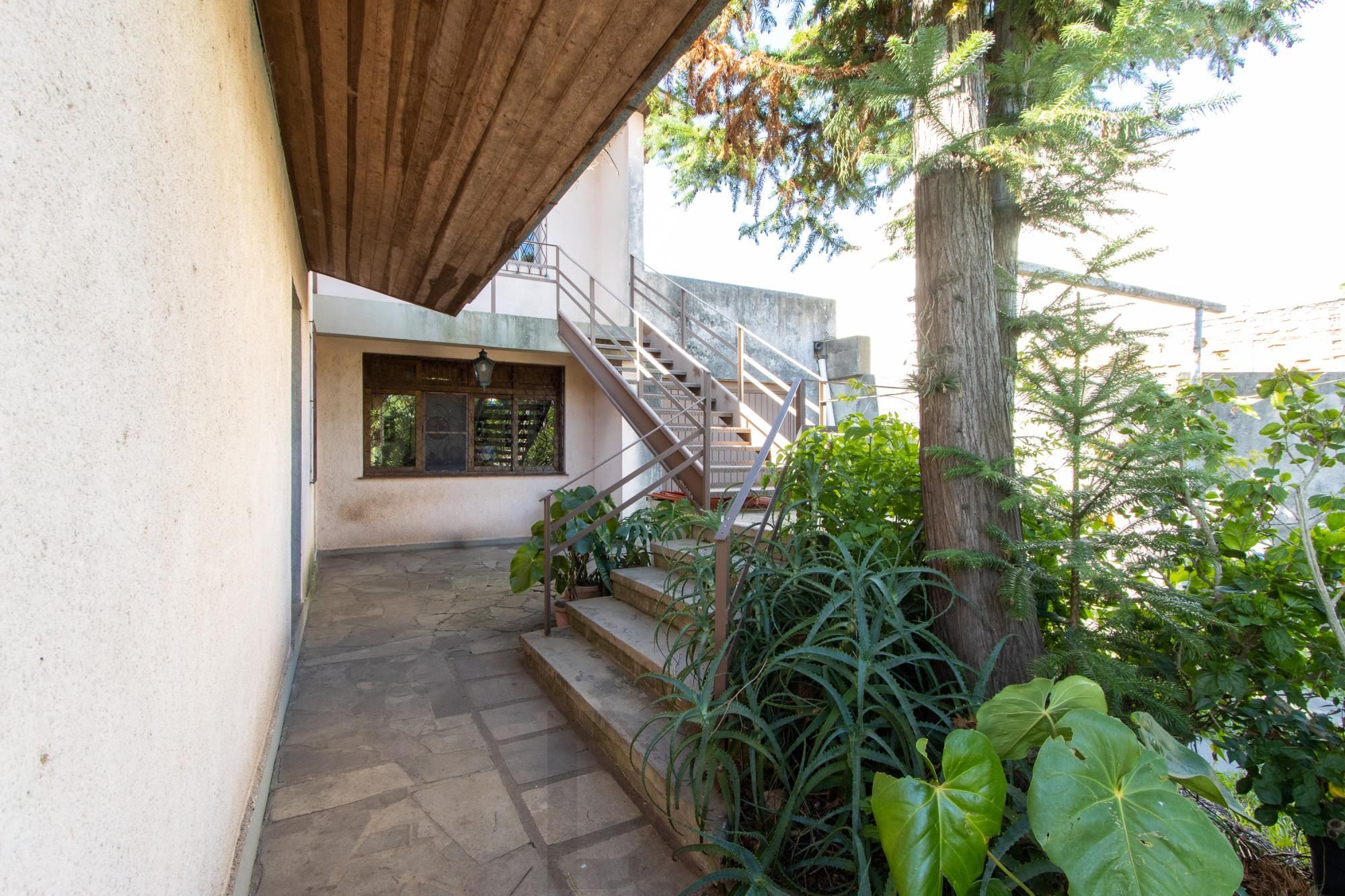Casa de Alvenaria, possui 3 dormitórios, uma suíte, hall de entrada, lavabo, living com lareira, cozinha ampla com armários, área gourmet com churrasqueira, corredor, pátio e 4 vagas de garagem, uma construção em anexo que possui hall de entrada, lavabo, living, cozinha, escritório, banheiro social — foto 5