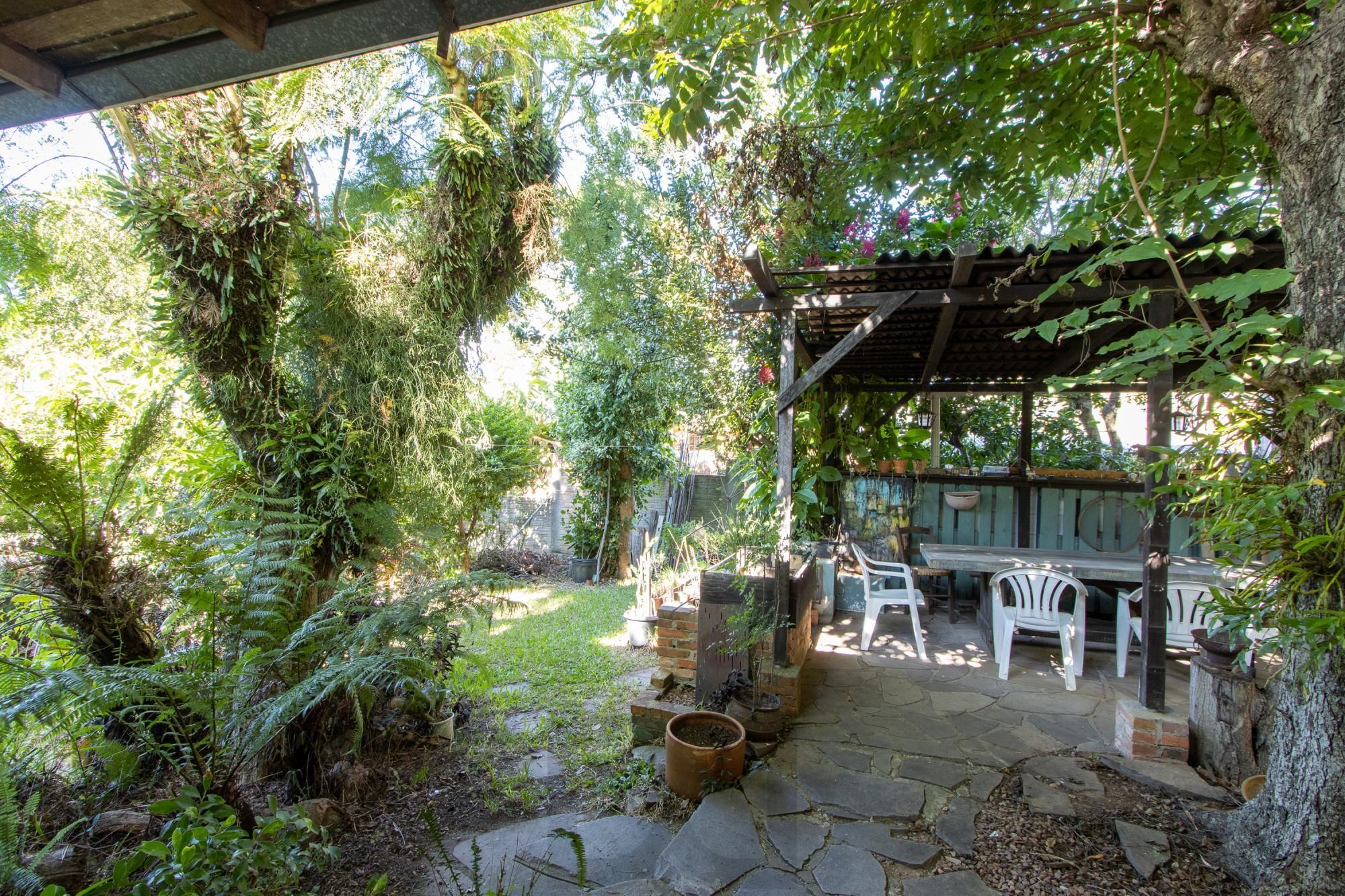 Casa de Alvenaria, possui 3 dormitórios, uma suíte, hall de entrada, lavabo, living com lareira, cozinha ampla com armários, área gourmet com churrasqueira, corredor, pátio e 4 vagas de garagem, uma construção em anexo que possui hall de entrada, lavabo, living, cozinha, escritório, banheiro social — foto 31