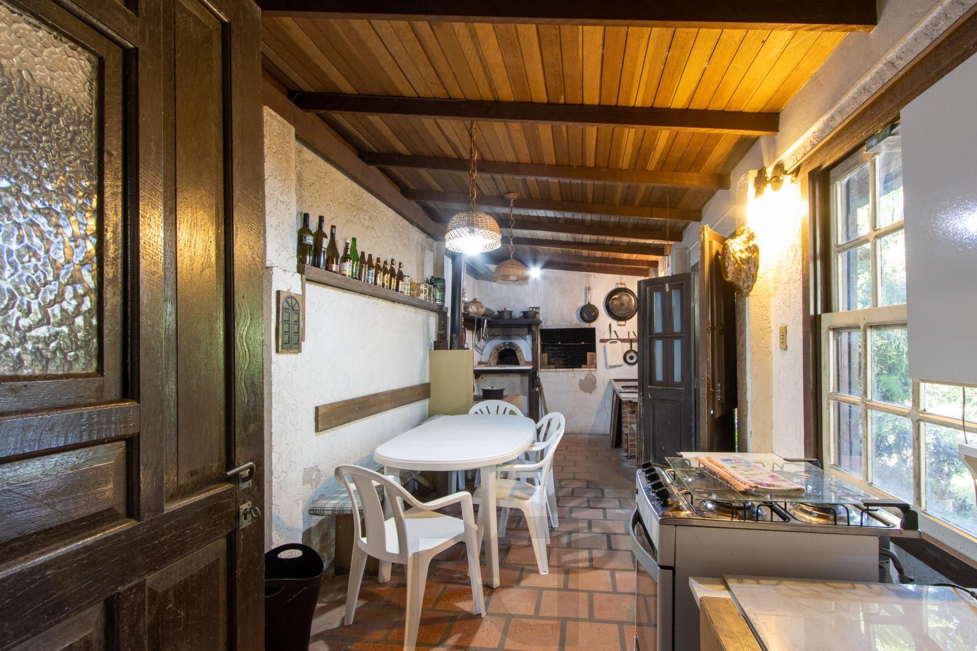 Casa de Alvenaria, possui 3 dormitórios, uma suíte, hall de entrada, lavabo, living com lareira, cozinha ampla com armários, área gourmet com churrasqueira, corredor, pátio e 4 vagas de garagem, uma construção em anexo que possui hall de entrada, lavabo, living, cozinha, escritório, banheiro social — foto 28