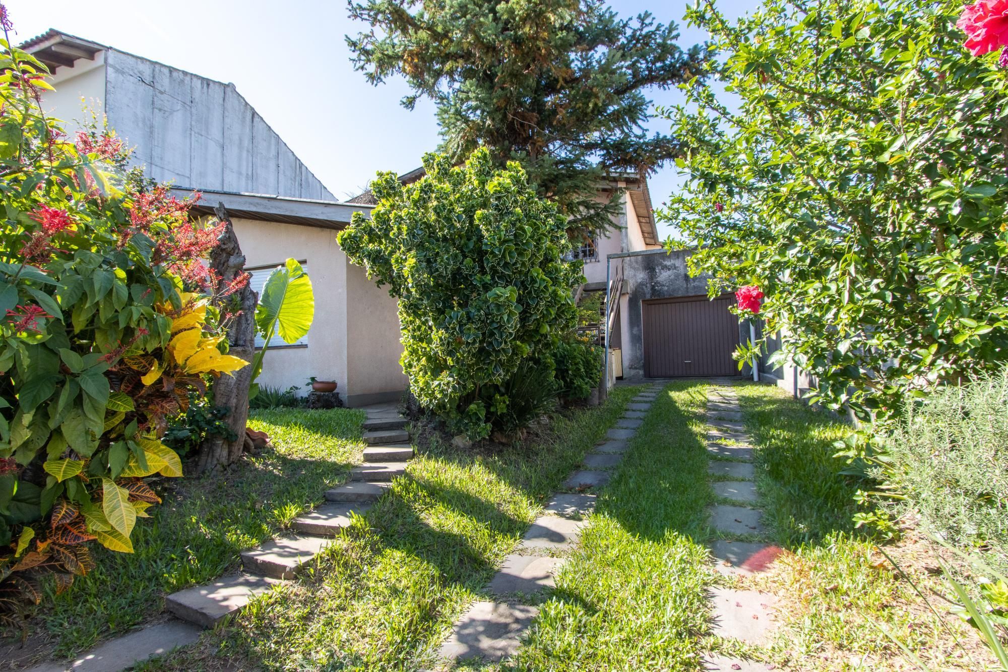 Casa de Alvenaria, possui 3 dormitórios, uma suíte, hall de entrada, lavabo, living com lareira, cozinha ampla com armários, área gourmet com churrasqueira, corredor, pátio e 4 vagas de garagem, uma construção em anexo que possui hall de entrada, lavabo, living, cozinha, escritório, banheiro social — foto 3