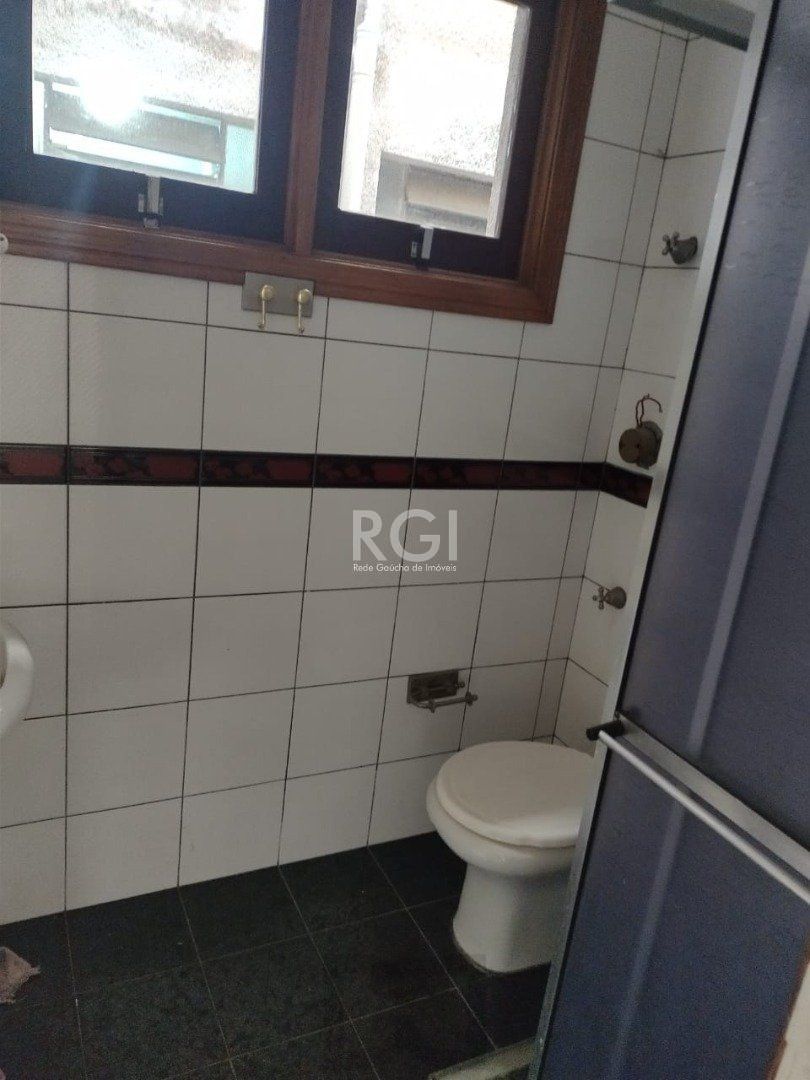 JK no Centro Histórico de Porto Alegre, com 26,01 m², cozinha com pia e armários, banheiro com box, piso com tabuão e orientação solar leste (sol da manhã). — foto 6