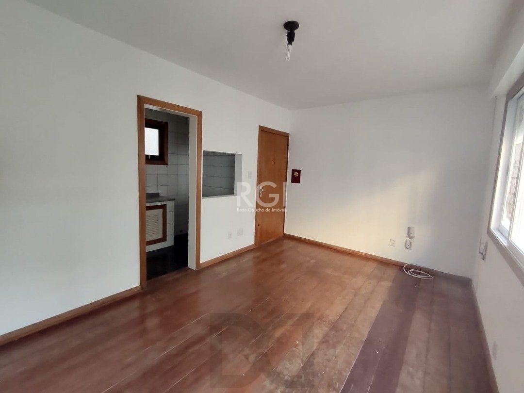 JK no Centro Histórico de Porto Alegre, com 26,01 m², cozinha com pia e armários, banheiro com box, piso com tabuão e orientação solar leste (sol da manhã). — foto 3